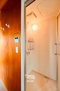 a bathroom with a shower and a glass door at OceansideRanch Miyazaki in Miyazaki