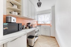 eine Küche mit weißen Schränken und einer Arbeitsplatte in der Unterkunft Sienna Velvet Room - Balneo & Cinema - Ligne 9 in Montreuil