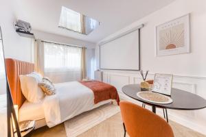 ein Schlafzimmer mit einem Bett und einem Tisch in der Unterkunft Sienna Velvet Room - Balneo & Cinema - Ligne 9 in Montreuil