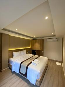 um quarto com uma cama grande com lençóis brancos em The Cozy Nest 2 - Thảo Điền em Cidade de Ho Chi Minh