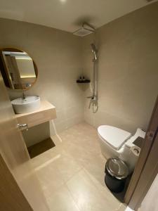 um banheiro com vaso sanitário, pia e espelho em The Cozy Nest 2 - Thảo Điền em Cidade de Ho Chi Minh