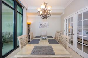 a dining room with a table and a chandelier at Phoenix West 1002 in Orange Beach
