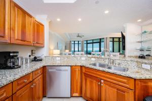 a large kitchen with wooden cabinets and a sink at Phoenix West 1002 in Orange Beach