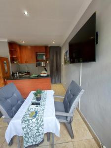 a living room with a table and chairs and a television at Lily's Inn in Centurion