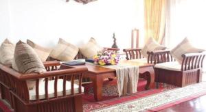 Daosavanh Resort & Spa Hotel في سافانخت: غرفة معيشة مع أريكة وطاولة وكراسي