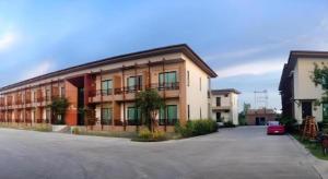 Villa Thiwa Hotel في Ban Na Po Tai: مبنى فيه سيارة متوقفة في موقف للسيارات