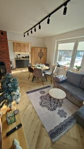 a living room with a couch and a table at Studio Góralskie Klimaty z widokiem na Góry, Kominek, Parking, Jacuzzi, Sauna in Biały Dunajec