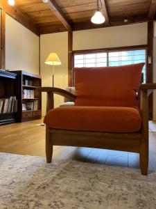 一軒宿 百々 private house rental doudou في Mitoyo: أريكة عليها وسادة برتقال في غرفة المعيشة
