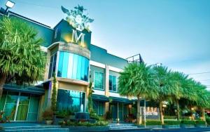 a building with palm trees in front of it at The Loom Rangsit in Ban Lam Phak Kut