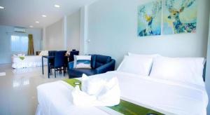 a bedroom with a white bed and a dining room at The Loom Rangsit in Ban Lam Phak Kut