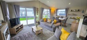 a living room with a couch and a tv and a table at Bay View Lodge in Heysham