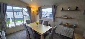 a dining room with a table and chairs and a window at Bay View Lodge in Heysham