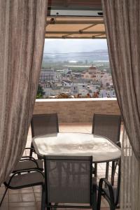 Una mesa y sillas en un balcón con vista. en Villa Thea, en Moírai