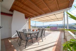 Un patio con una mesa y sillas en un balcón. en Villa Thea, en Moírai