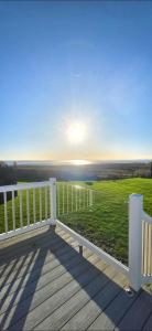 a deck with a view of a green field at Bay View Lodge in Heysham