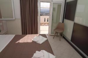 Una habitación de hotel con una cama y una ventana. en Villa Thea, en Moírai