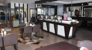 a restaurant with a bar with tables and chairs at Balai View Hotel in Tanjung Balai Karimun