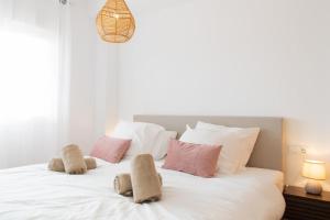 a bedroom with a white bed with pink and white pillows at 2BR Ontspannen vakantiewoning in Casares +10 photos