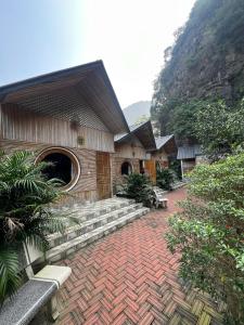 Trang An Maison Retreat في Nguyên Ngoại: مبنى ذو فناء من الطوب الأحمر مزود بمقاعد