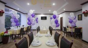 a banquet hall with purple balloons and tables and chairs at The Mou Hotel in Phnom Penh