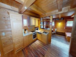Una cocina con gabinetes de madera y un comedor con mesa. en Chalet in Neukirchen, en Neukirchen am Großvenediger