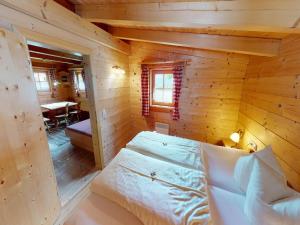 Un dormitorio en una cabaña de troncos con una cama dentro. en Chalet in Neukirchen, en Neukirchen am Großvenediger