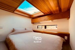 a bedroom with a large bed with a skylight at OceansideRanch Miyazaki in Miyazaki
