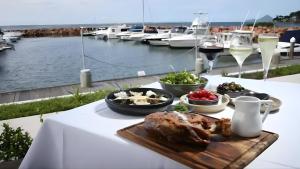 a plate of food on a table with a view of a marina at Pacific Blue Poolside Escape - Oaks Port Stephens Pacific Blue Resort in Salamander Bay