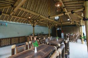 a dining room with wooden tables and chairs at Malioboro Garden Hotel Yogyakarta in Yogyakarta