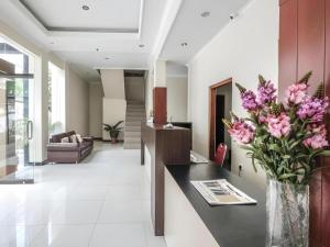 a living room with a vase of flowers on a table at Malioboro Garden Hotel Yogyakarta in Yogyakarta