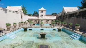 a large house with a swimming pool in a yard at Malioboro Garden Hotel Yogyakarta in Yogyakarta