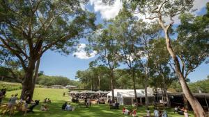 a group of people in a park with tents at Pacific Blue Poolside Escape - Oaks Port Stephens Pacific Blue Resort in Salamander Bay