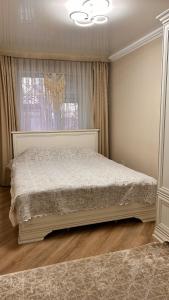 een slaapkamer met een groot bed voor een raam bij Apart on Arbat Standard in Simkent