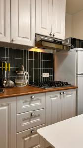 een keuken met witte kasten en een roestvrijstalen koelkast bij Apart on Arbat Standard in Simkent