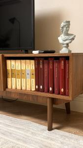 een boekenplank vol boeken met een beeld bij Apart on Arbat Standard in Simkent