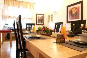 una sala da pranzo con tavolo in legno e sedie di Domus Cavour Guest house a Roma