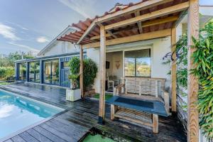 a home with a swimming pool and a pergola at Villa Saint Barth in Gujan-Mestras