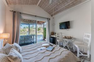 a living room with a bed and a tv at Villa Saint Barth in Gujan-Mestras