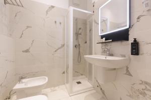 a white bathroom with a sink and a shower at Hotel 22 Marzo in Milan