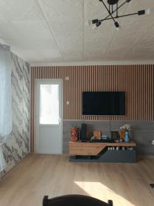 ein Wohnzimmer mit einem Flachbildfernseher an der Wand in der Unterkunft Апартамент за гости Парадайс in Malko Tŭrnovo