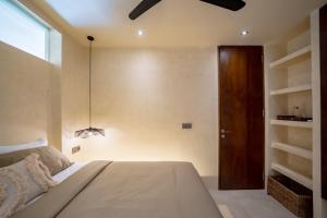 a bedroom with a bed and a wooden door at Casa Beso Balangan in Badung +29 photos