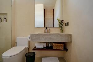 a bathroom with a sink and a toilet at Casa Beso Balangan in Badung