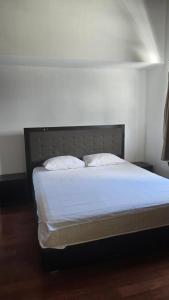 een bed met witte lakens en kussens in een kamer bij Villa Don Bose 8 in Jimbaran