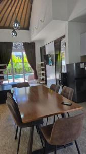 een eetkamer met een houten tafel en stoelen bij Villa Don Bose 8 in Jimbaran