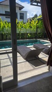 een uitzicht op een zwembad door een glazen schuifdeur bij Villa Don Bose 8 in Jimbaran
