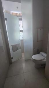 een witte badkamer met toilet en douche bij Villa Don Bose 8 in Jimbaran +8 foto's