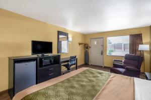 Econo Lodge Easton Route 50 في إيستون: غرفة فندقية تحتوي على سرير ومكتب وتلفزيون