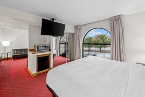 ブランソンにあるClarion Inn Bransonのベッドとテレビがあるホテルの部屋