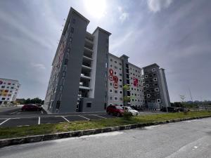 a large building with cars parked in a parking lot at Homestay Kesidang in Seri Iskandar