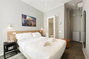 a bedroom with a large white bed with towels on it at Hotel 22 Marzo in Milan